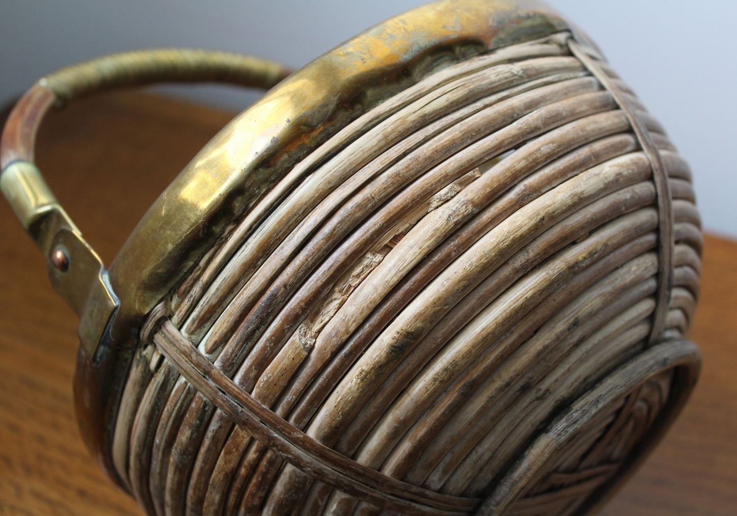 Vintage wicker, cane basket with brass edging showing close up of side