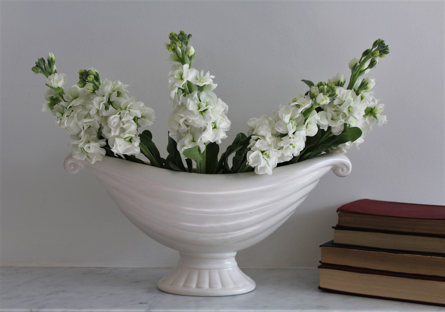 White vintage mantle vase with twin scroll handles by Price Bros (later Price and Kensington), c1930 with stack of books