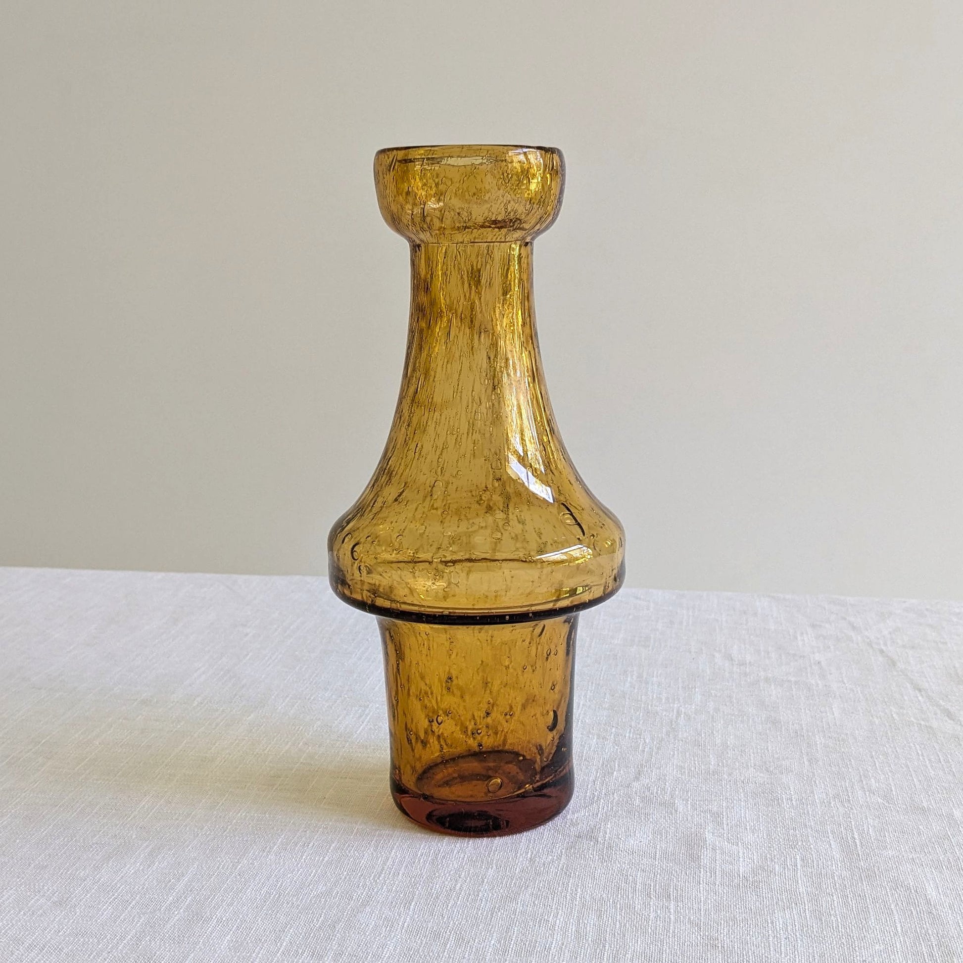 Amber glass vase on a table with a white background