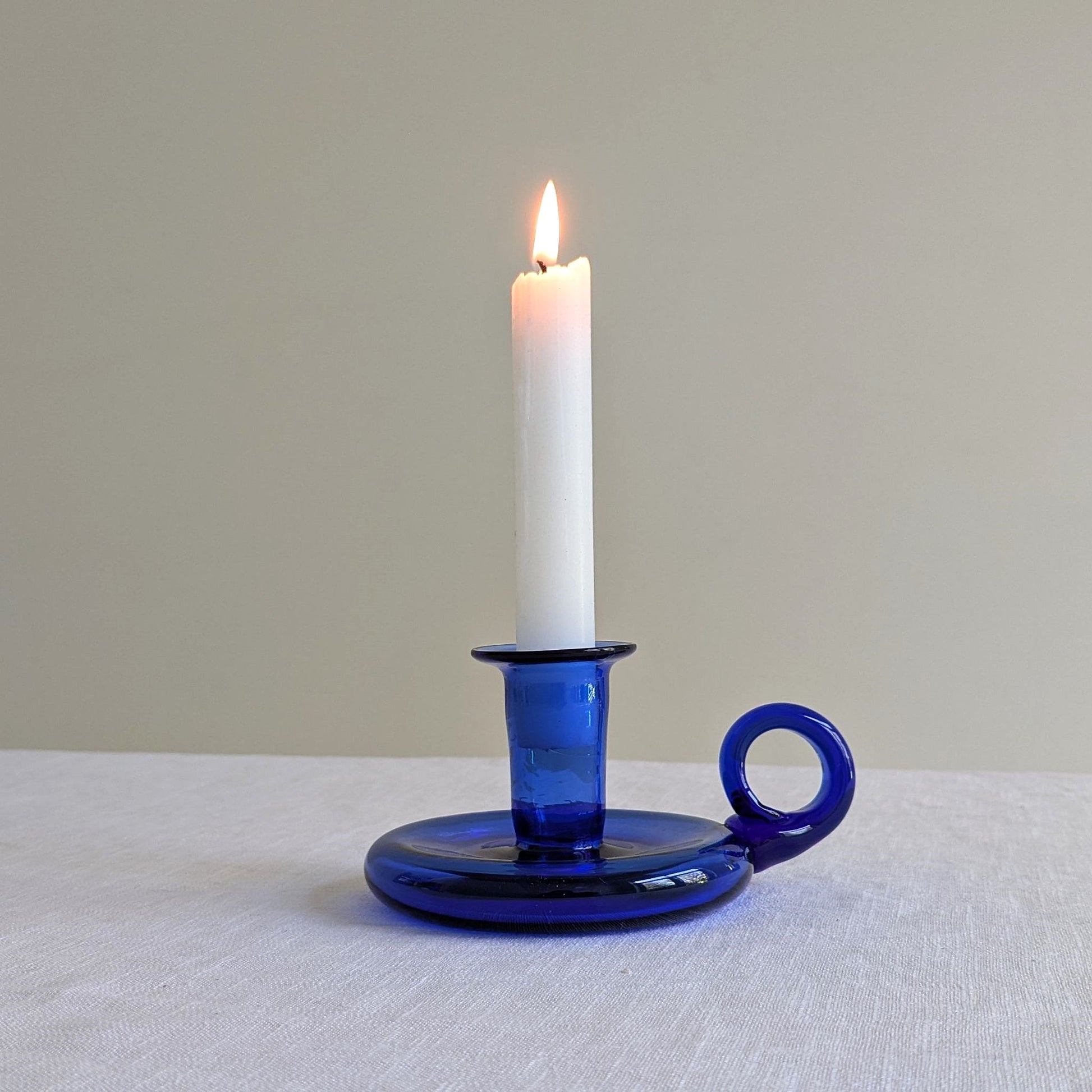 Blue glass chamberstick on a white background