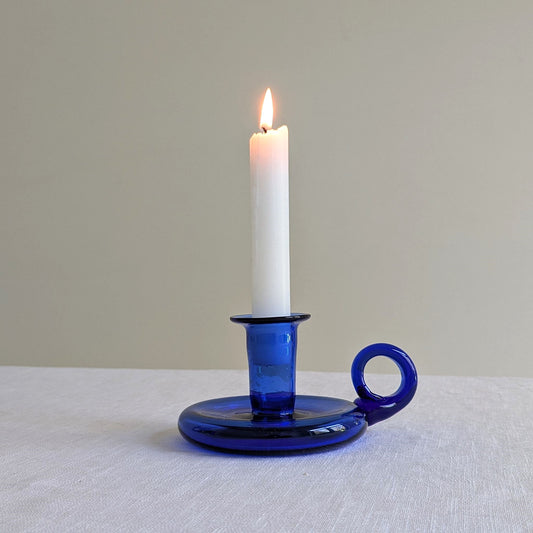 Blue glass chamberstick on a white background